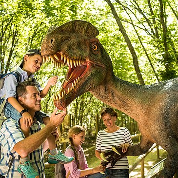 Das Bild zeigt eine Familie im Dinopark Teufelsschlucht.