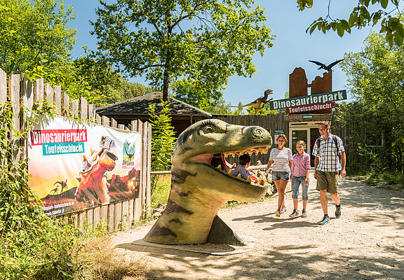 Das Bild zeigt eine Familie im Dinopark Teufelsschlucht.