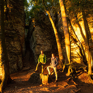 Das Bild zeigt bei Wanderer vor Felswänden beim Sonnenuntergang.